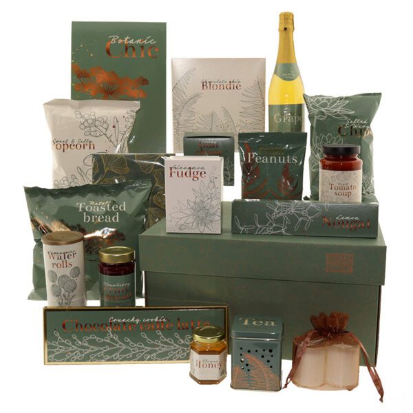 The Botanic Chic gift box with gourmet items in green and gold botanical-themed packaging, including grape drink, nuts, bread, popcorn, rolls, fruit spread, blondie, fudge, cheese, peanuts, soup, nougat, café latte, tea, honey, and candles.